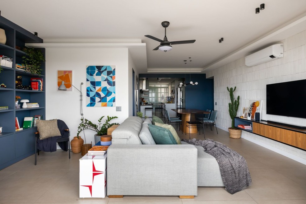 Plaquetas cerâmicas e revestimentos cimentícios podem ser boas opções para apartamentos e espaços onde não há possibilidade de criar uma nova parede de alvenaria. A parede da sala de estar foi revestida com tijolinhos Rustic Fit Neve, da Gauss, na São Geraldo — Foto: Júlia Tótoli/Divulgação | Projeto do escritório Mariana Jerônimo Arquitetura