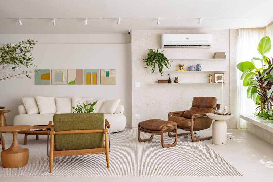 SALA DE ESTAR | A chaise Pitu, de Aristeu Pires, ocupa o canto de leitura ao lado do banco-jardineira, que aproxima a vegetação dos interiores. A composição de quadros é de Thomaz Velho sobre a parede com textura da I Colori di Venezia. Tapete da Galeria Hathi. A iluminação em trilho é da Dimlux