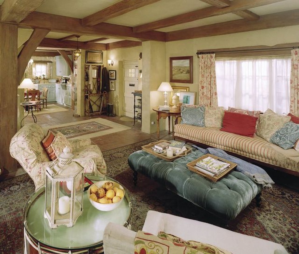 A sala de estar do Rosehill Cottage reúne poltronas estofadas, tecidos florais e listrados, móveis antigos e um pufe no centro da área de convivência. Os interiores foram montados em estúdio para o filme — Foto: Columbia Pictures/Divulgação