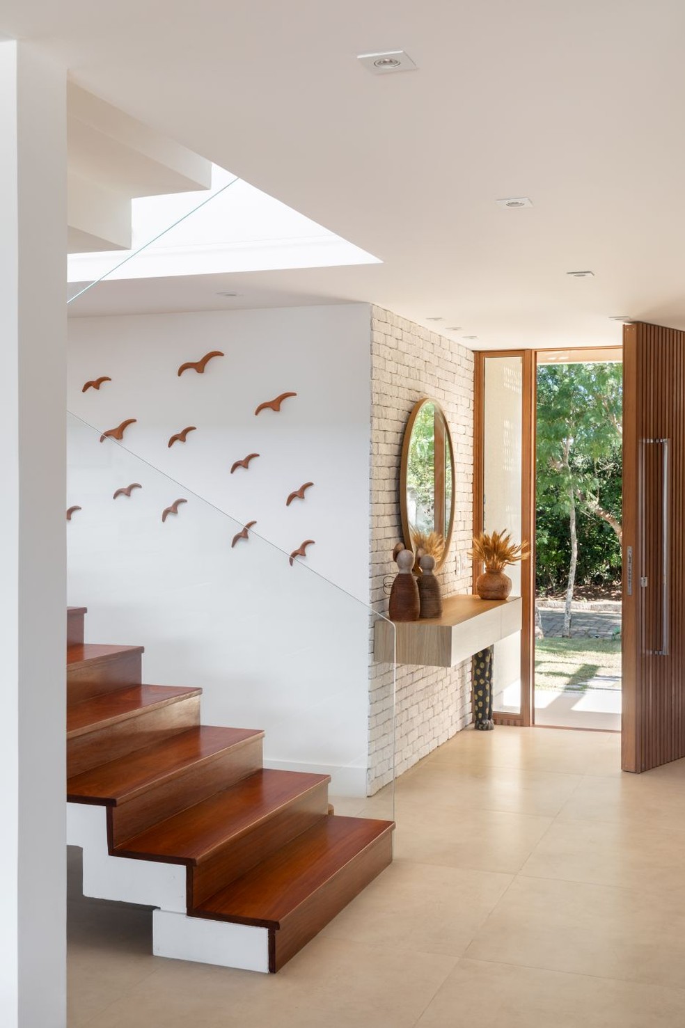 Plaquetas cerâmicas e revestimentos cimentícios são opções para conquistar o visual do tijolinho em apartamentos e espaços com pouca possibilidade de intervenção. Na parede revestida de tijolinho cimentício branco, da Passeio, foi instalado o aparador desenhado pela arquiteta e executado em MDF com acabamento melamínico no padrão freijó por marceneiro autônomo — Foto: Luiza Schreier/Divulgação | Projeto da arquiteta Amanda Miranda