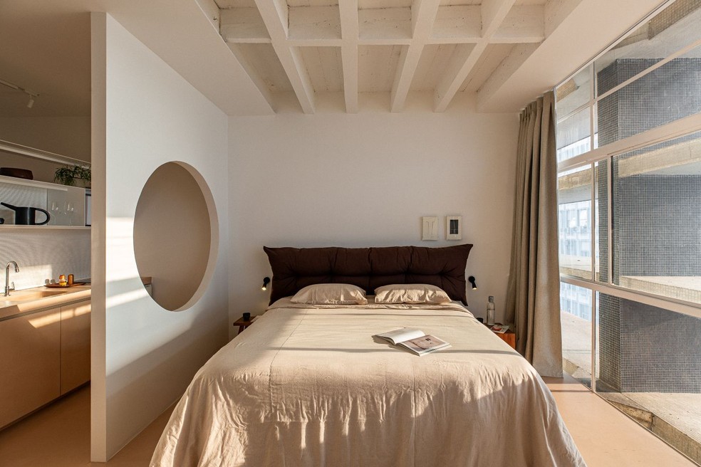 Modelos estofados podem ser revestidos com tecidos como linho, bouclé, veludo, lona, suede e couro, cada um com características próprias. Cama com cabeceira estofada, da loja Meninos na Casinha.Roupa de cama de linho natural, da marca Casa Sonno — Foto: Miti Sameshima/Divulgação | Projeto da arquiteta Fernanda Altemari