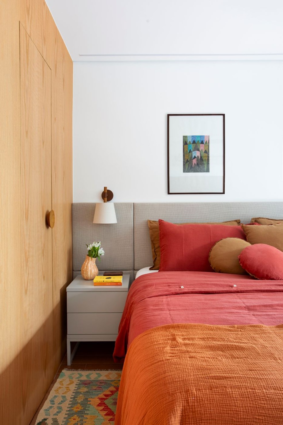 Em quartos pequenos, cabeceiras com linhas simples e integradas à parede ajudam a ampliar visualmente o ambiente. A cabeceira estofada da Florense Barra, que também forneceu o gaveteiro cinza, é o pano de fundo neutro para a cama — Foto: Juliano Colodeti/MCA Estúdio/Divulgação | Projeto do escritório Beta Arquitetura