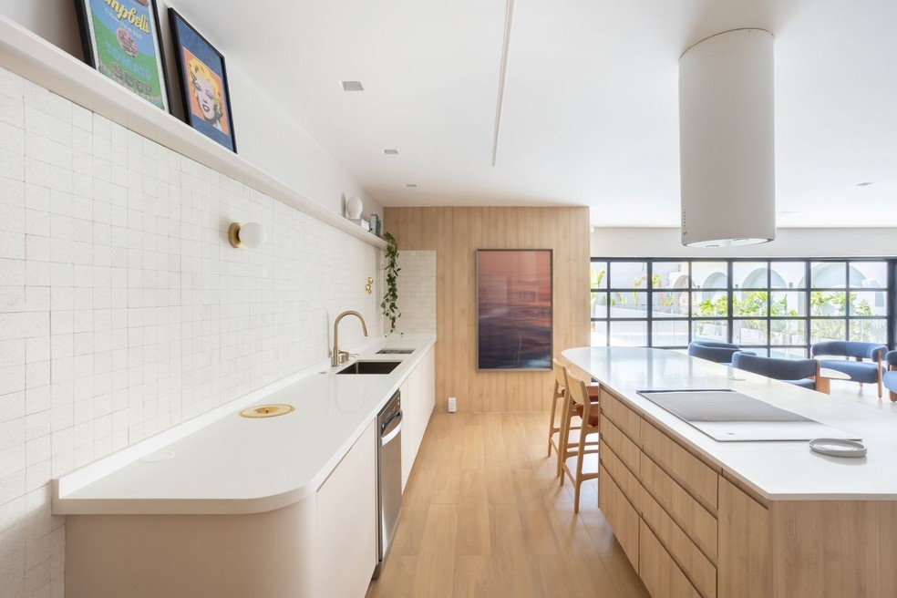 Torres retráteis e módulos embutidos no mesmo nível da bancada da cozinha exigem um acabamento preciso para garantir o efeito discreto — Foto: Dam Mol/Divulgação | Projeto do escritório Loft 7
