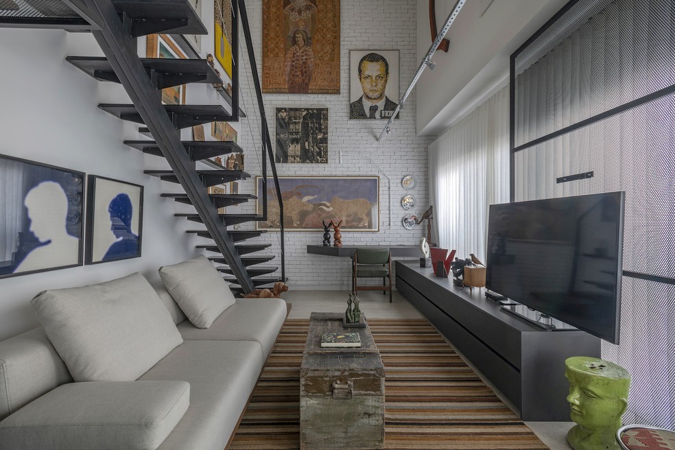 Uma parede inteira de tijolinhos brancos pode criar unidade visual e se tornar o principal elemento arquitetônico do ambiente. As paredes com tijolinho serviram como uma "página em branco" para expor os quadros da coleção do casal — Foto: Estúdio ny18/Divulgação | Projeto do escritório Piascesi Arquitetos Associados