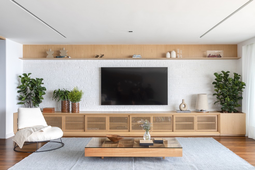 Para evitar que uma composição predominantemente branca pareça fria, combine o tijolinho com madeira, fibras naturais, tecidos e pontos de cor. A escolha do tijolinho para o revestimento da sala de TV deixa o ambiente mais aconchegante — Foto: Juliano Colodeti/MCA Estúdio/Divulgação | Produção: Lu Algarte/Divulgação | Projeto do escritório Tripper Arquitetura
